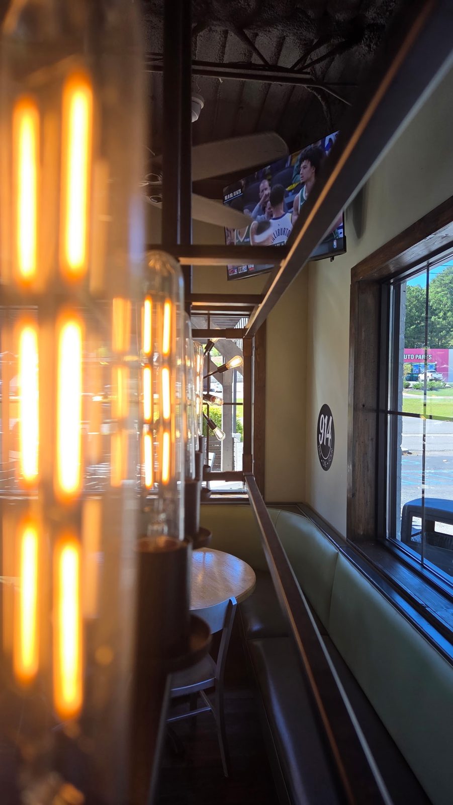 Booth seating by the window under hanging Edison bulbs